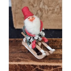 Old pinecone elf on a sledge with boots, h: 9 cm.