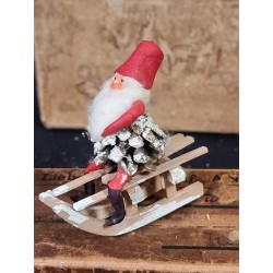 Old pinecone elf on a sledge with boots, h: 9 cm.