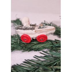 Snowchild in pine cone wagon, size: 8 x 3,5 cm.