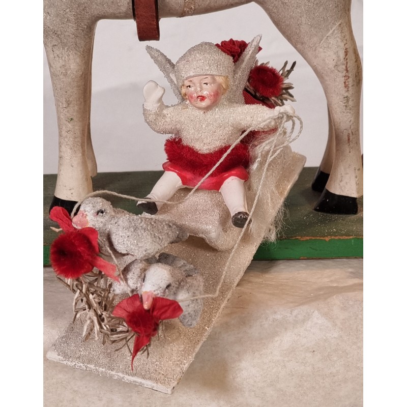 Snow angel on a sledge with 2 pigeons in front, size: 7,5 x 13 cm.