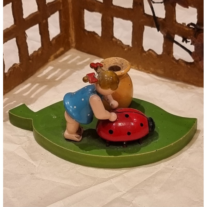 Old Erzgebirge ornament, girl on a leaf pushing a ladybug, size: 5 x 9,5 cm.