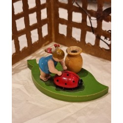 Old Erzgebirge ornament, girl on a leaf pushing a ladybug, size: 5 x 9,5 cm.
