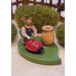 Old Erzgebirge ornament, girl on a leaf pushing a ladybug, size: 5 x 9,5 cm.