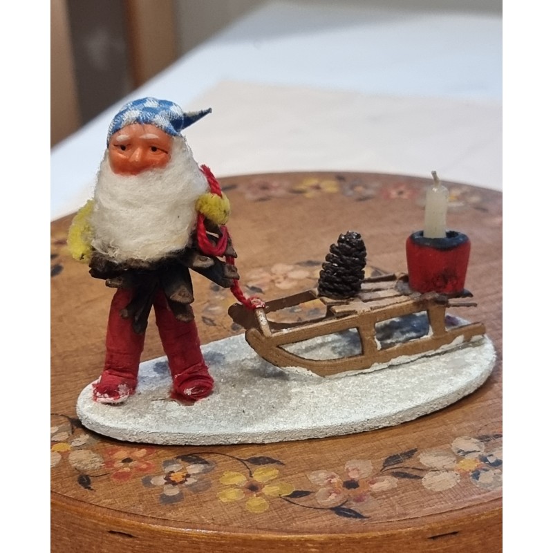 Old pine cone elf with a sledge, h: 8 cm.