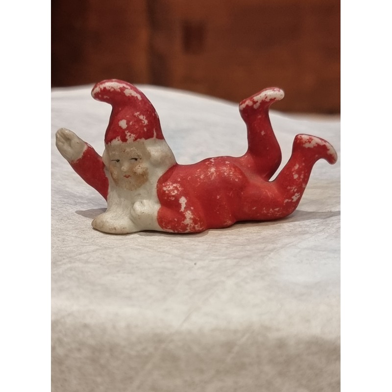Antik bisquit nisse med løftet arm, mål: 3,5 x 6,5 cm.